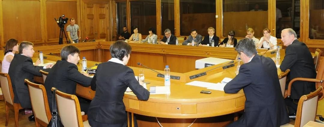 A press conference around a large curved table