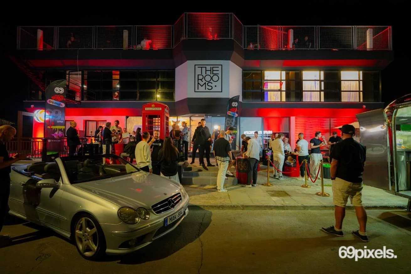 THE ROOMS building at night, lit red, with guests arriving for the masquerade and a red phone box by the door