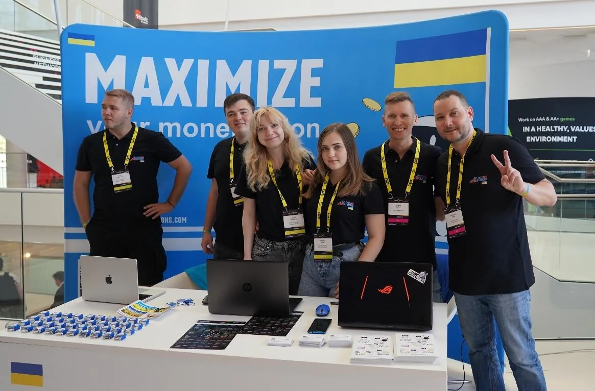 The CAS team in black shirts at their blue “MAXIMIZE” stand with laptops on the counter